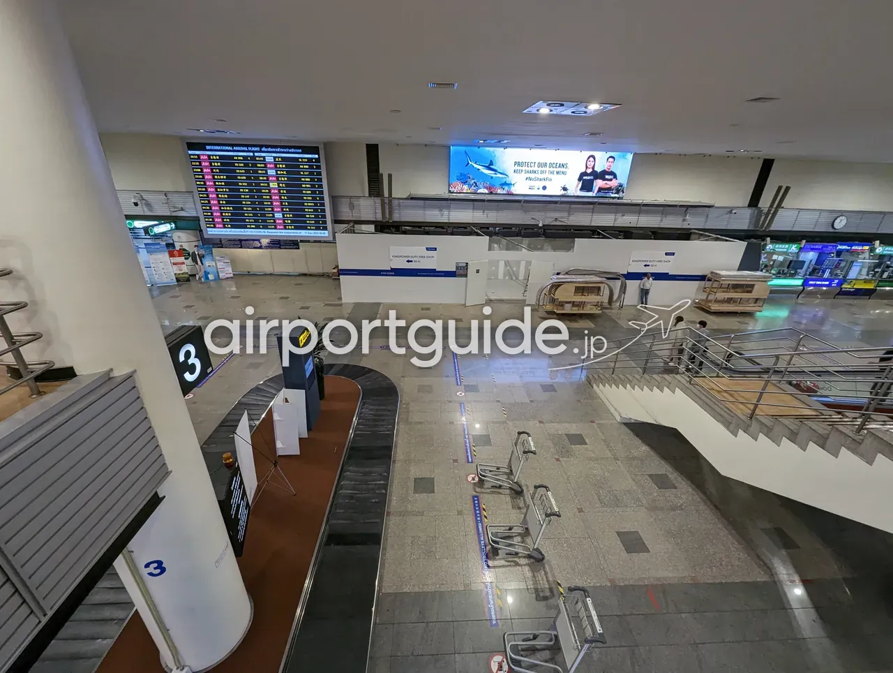 上階から見下ろしたドンムアン空港の国際線手荷物受取エリア。「3」番のターンテーブルと手荷物カート、上部に「INTERNATIONAL ARRIVAL FLIGHT」の案内板と「KINGPOWER DUTY FREE SHOP」への誘導サインが見える。