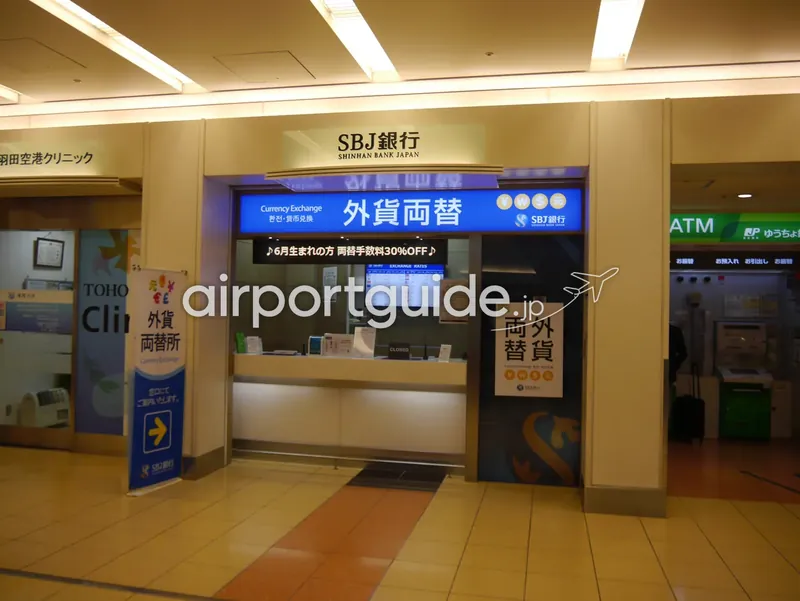 羽田空港のSBJ銀行（新韓銀行）外貨両替カウンター。左に羽田空港クリニック、右にゆうちょ銀行ATM。