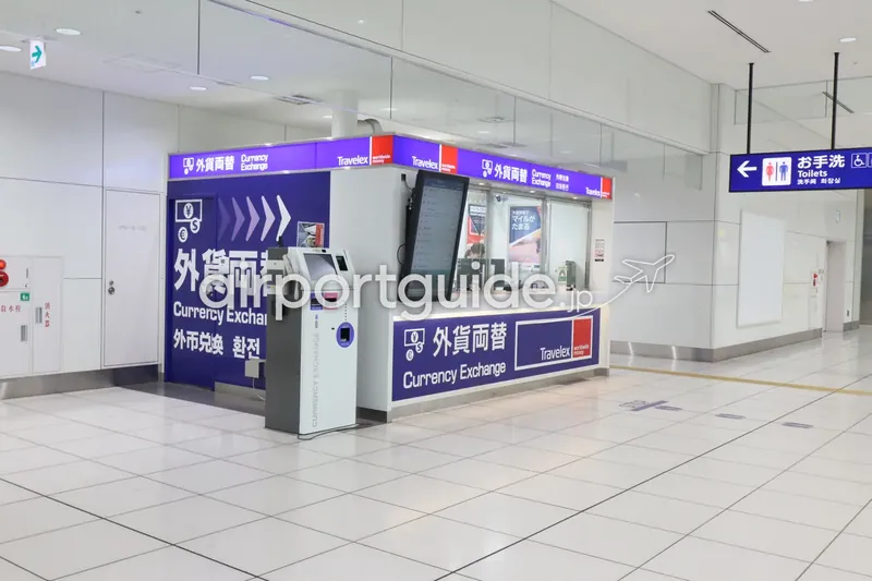 トラベレックス（Travelex）の両替カウンター。有人窓口と自動両替機、レート表示モニタが並ぶ。取り扱い通貨数は空港で最多。