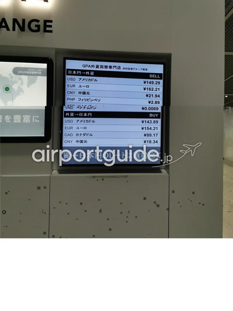 羽田空港の外貨両替所のレート表示モニター。円と各国通貨の売買レートが一覧で表示されている。