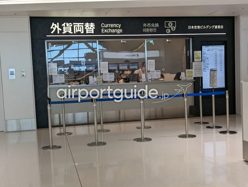 羽田空港の外貨両替カウンター（日本空港ビルデング直営店）と為替レート掲示板。手前は無人でCLOSEDの表示。