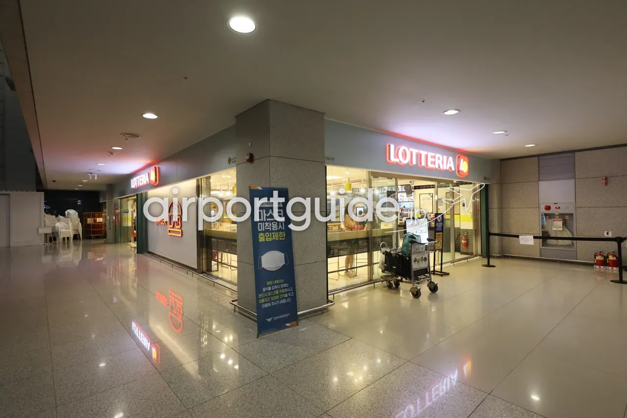 仁川空港到着エリアのファストフード店「LOTTERIA」と「BURGER LAB」。夜、赤いネオン看板が光る。