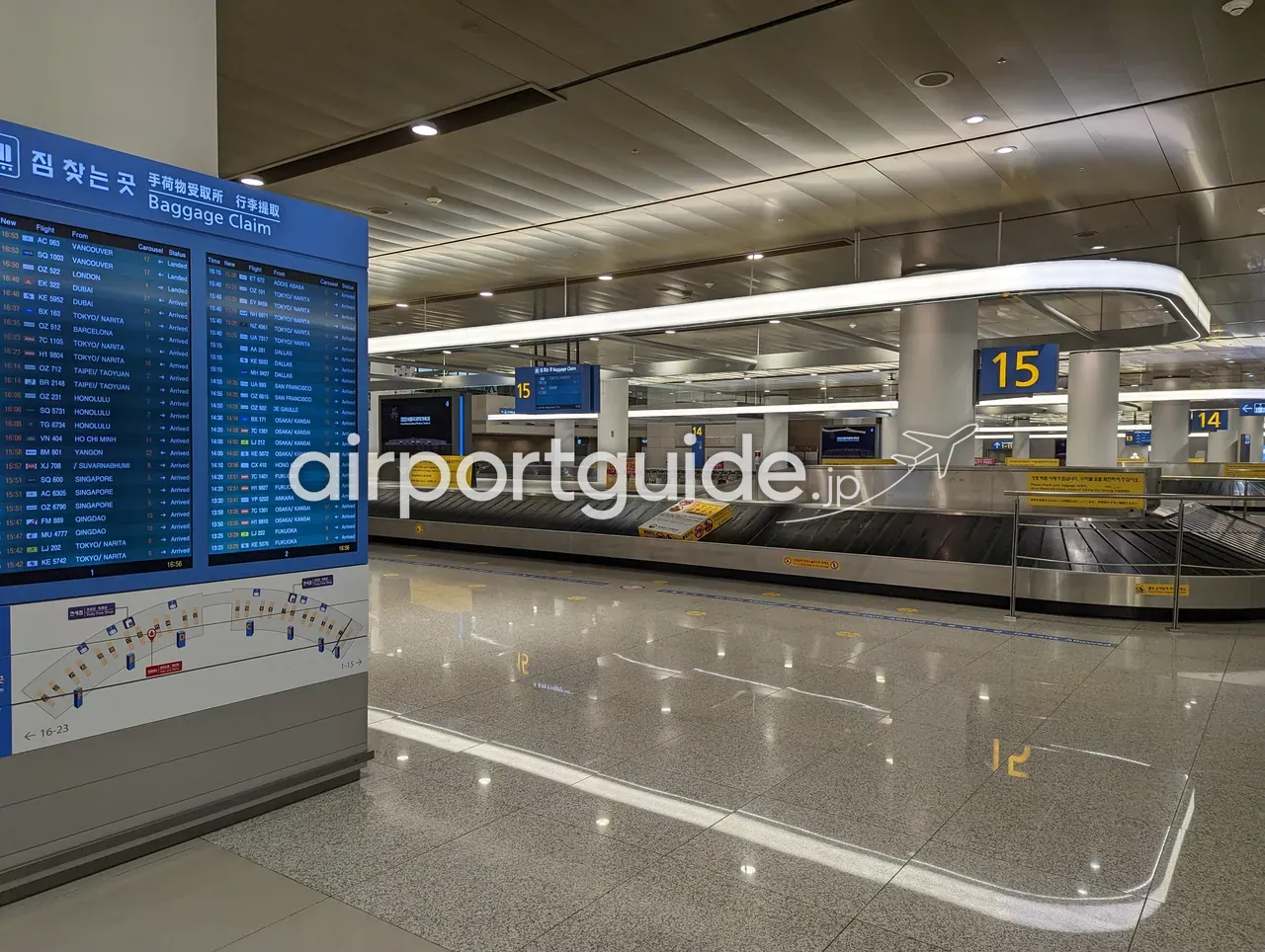 仁川空港の手荷物受取所。「짐 찾는곳 手荷物受取所 Baggage Claim」の大型案内板に東京/成田・大阪/関西など多数の便名が表示され、14・15番の無人ターンテーブルが並ぶ。