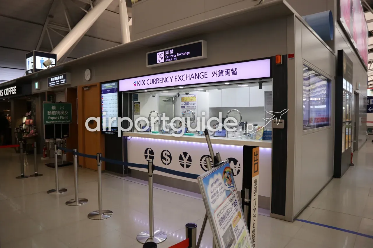 関西空港の出国階にある「KIX CURRENCY EXCHANGE 外貨両替」窓口。上部に『両替 Currency Exchange』のサイン、隣に動植物検疫やスターバックスが並ぶ一角。