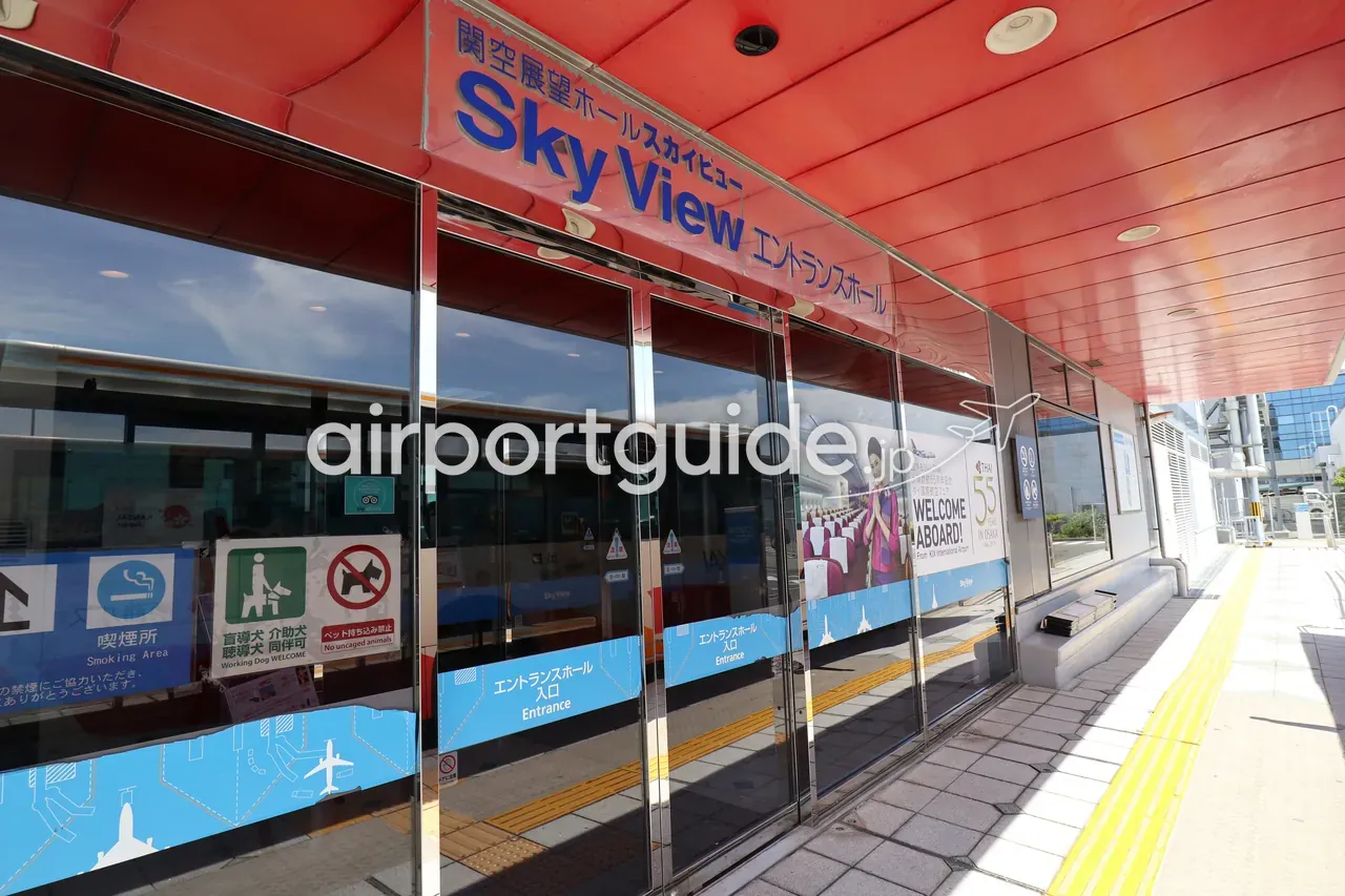 関空展望ホール スカイビューのエントランスホール入口。赤い天井の下、ガラス扉に「Sky View エントランスホール」の看板とタイ国際航空の歓迎ポスター。