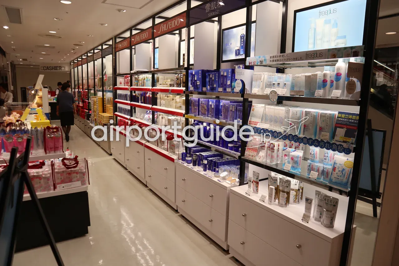 関西空港免税エリアの化粧品店内。資生堂・雪肌精・フリープラスなど日本ブランドのスキンケアが棚に並ぶ。