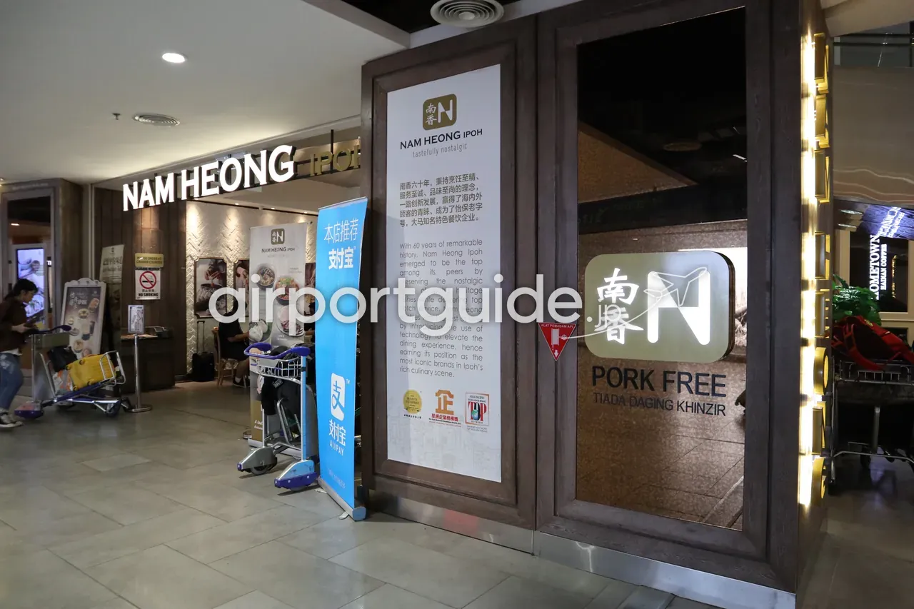 gateway@klia2のレストラン「NAM HEONG IPOH」の店先。「tastefully nostalgic」「60 years」の紹介パネルと「PORK FREE / TIADA DAGING KHINZIR」の表示、老舗コピティアム系の内装。