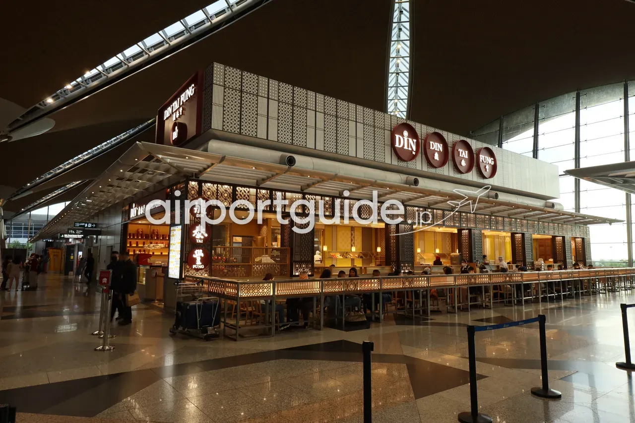KLIAターミナル1の飲食店「DIN TAI FUNG（鼎泰豐）」。イスラム文様のスクリーンをあしらった店構えとカウンター席が、波打つ大屋根の広いコンコースに面して並ぶ。