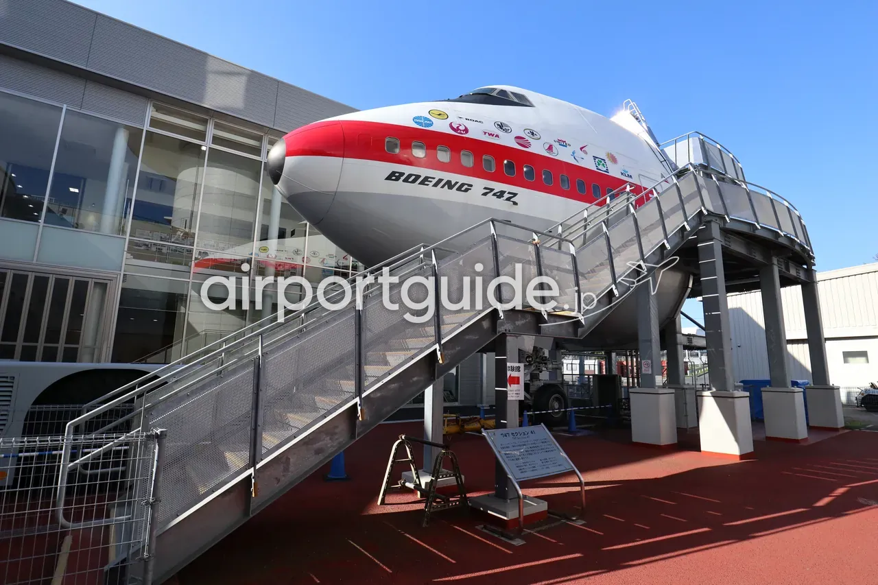 航空科学博物館の屋外展示、ボーイング747の前部胴体（機首部分）。見学用のタラップが設置され、青空が広がる。