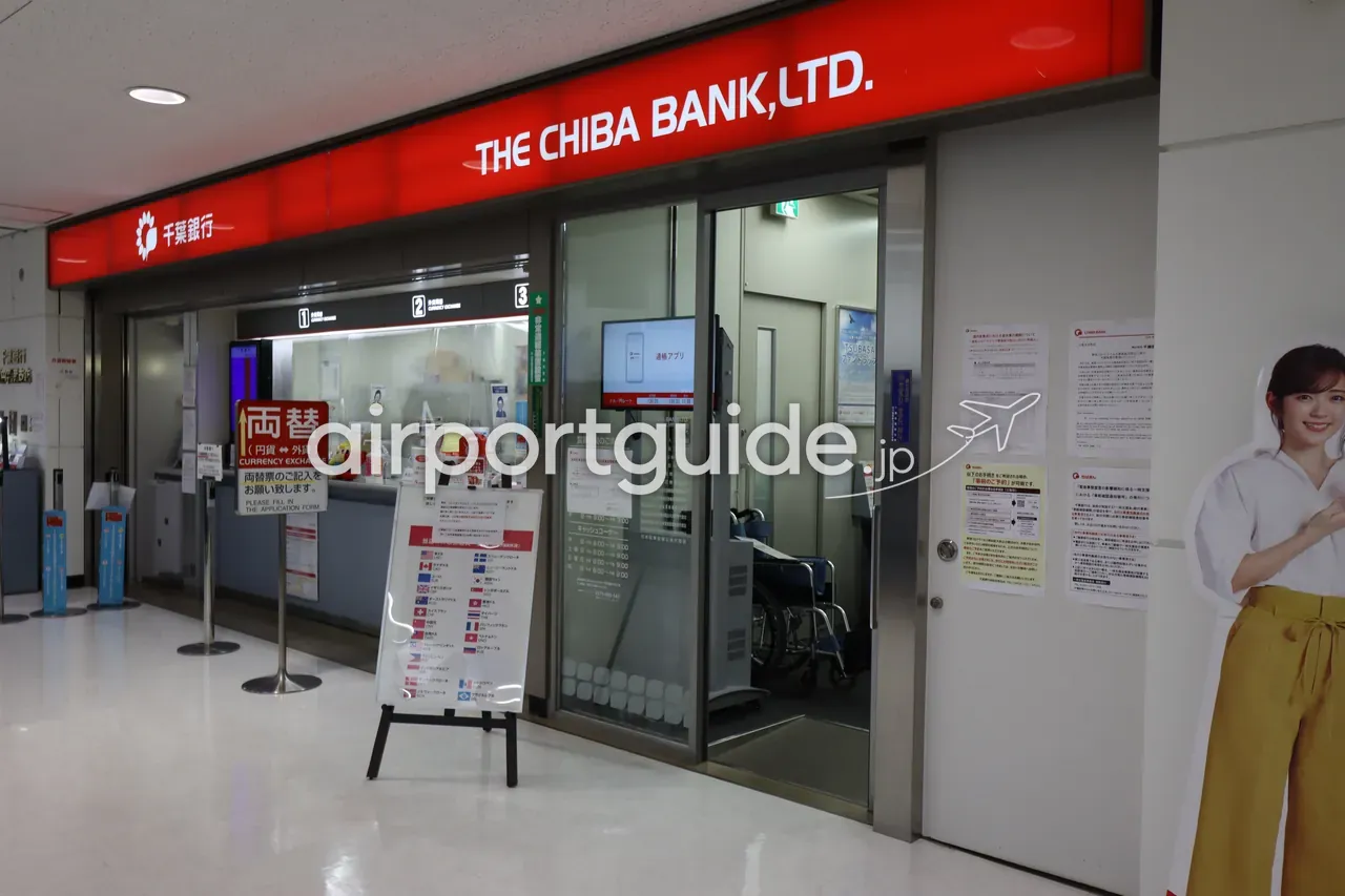 成田空港 第2ターミナルの千葉銀行の外貨両替カウンター。窓口に係員がいて、取扱通貨の案内板が置かれている。