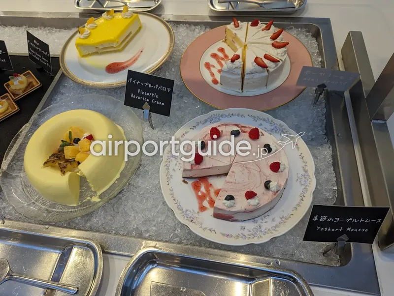 デザートコーナー。氷の上に皿盛りのケーキ類とネームプレートが並ぶ。
