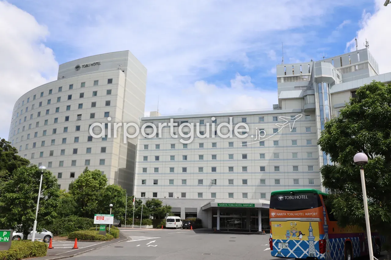 成田東武ホテルエアポートの外観。円弧状に伸びた高層棟と、車寄せに停まる送迎バス。