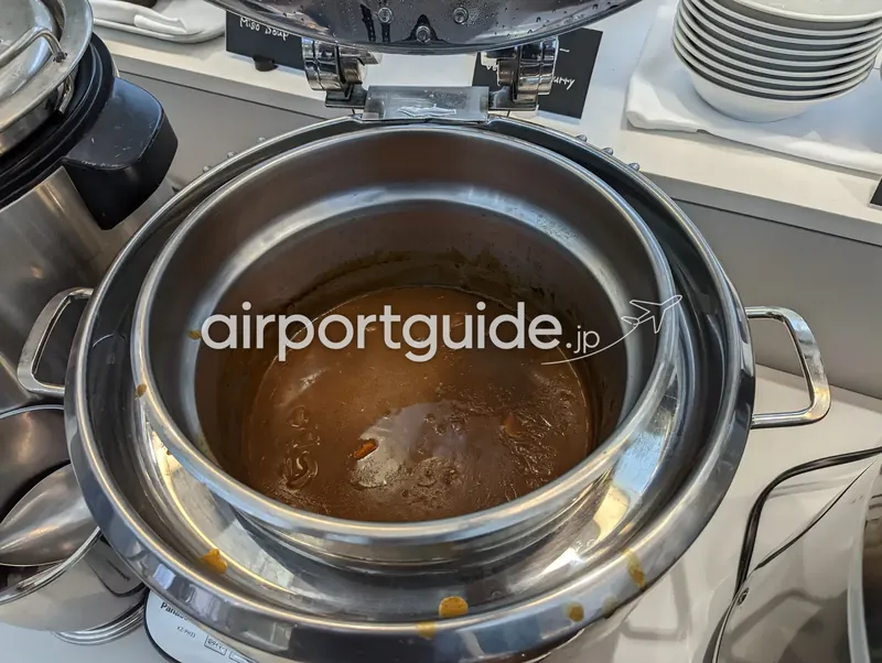 カレーの保温鍋。蓋を開けた鍋に茶色いカレーが入る。