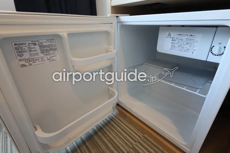 ホテル客室の空の小型冷蔵庫（扉を開けた状態）。