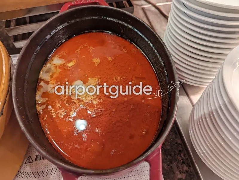 鋳物鍋の赤いカレー（魚介レッドカレーと見られる）。