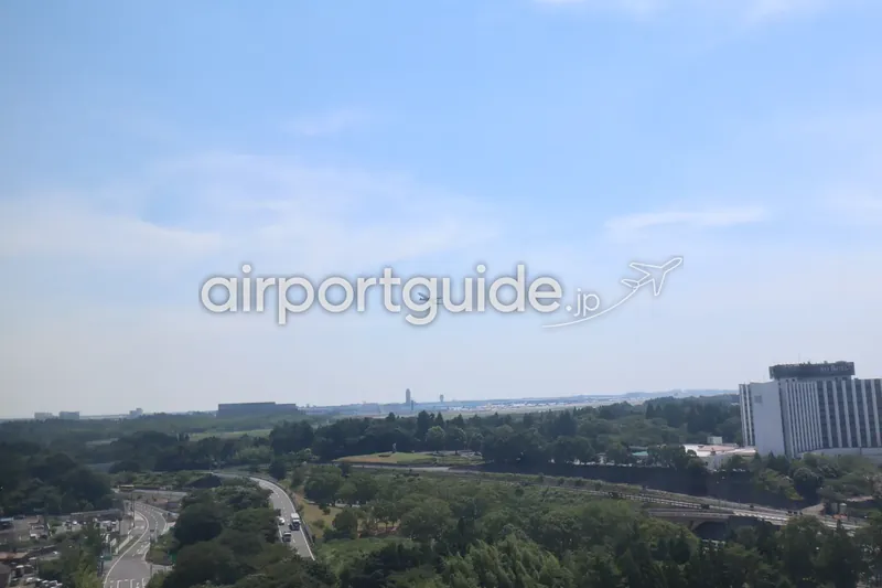 成田空港を離陸し上昇する旅客機を、周辺の風景とともに捉えた構図。
