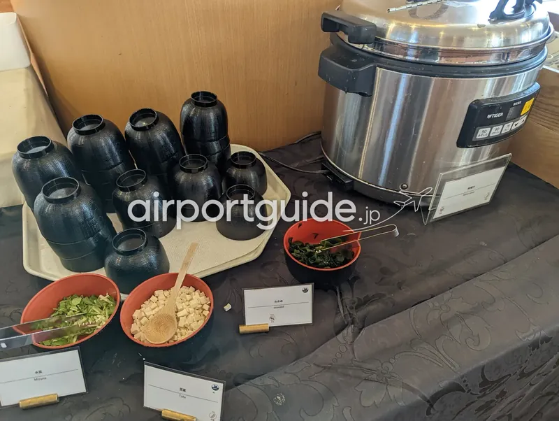 味噌汁コーナー。水菜・豆腐・わかめの具材と汁椀、電気スープジャー。