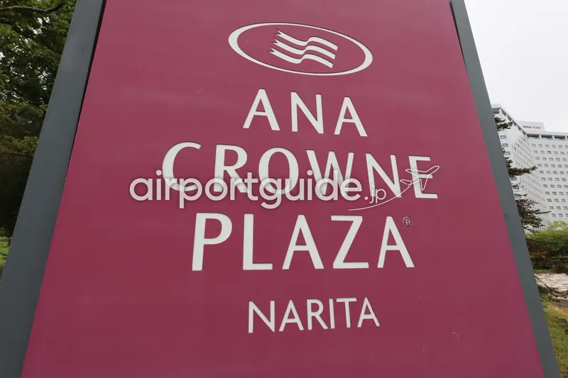 『ANA CROWNE PLAZA NARITA』のホテル看板クローズアップ。奥に白いホテル棟。