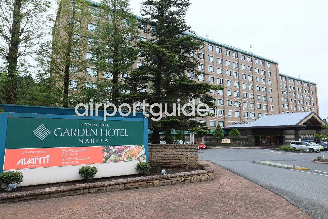 インターナショナルガーデンホテル成田の外観。「INTERNATIONAL GARDEN HOTEL NARITA」の緑の看板と、背後にそびえるレンガ調の大きな客室棟、右手に車寄せ。