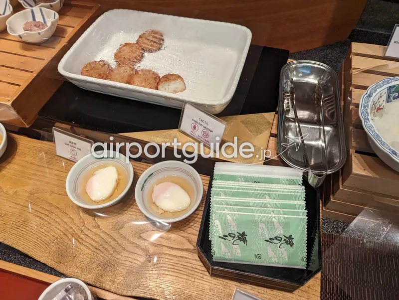 和惣菜。じゃこ天（揚げ天）と温泉卵、緑の和柄ナプキン。