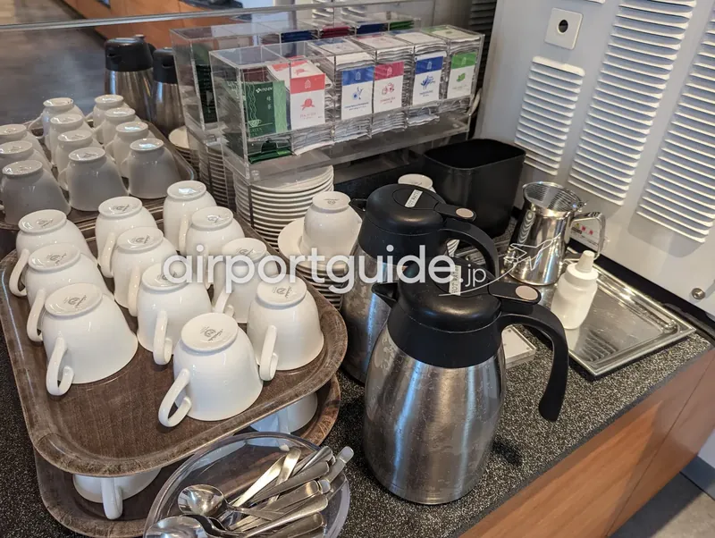 ドリンクコーナー。伏せたティーカップと各種ティーバッグ、給湯ポット。