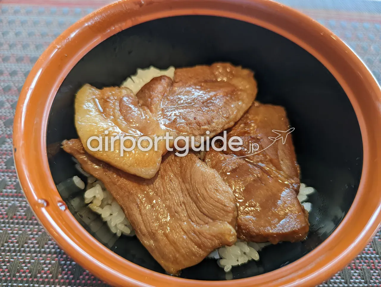 ANAクラウンプラザホテル成田の朝食の豚丼。朱色の器に、甘辛く煮た豚肉をごはんにのせて盛り付けられている。