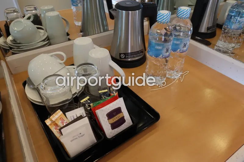 客室のコーヒー・紅茶トレーと電気ケトル、天然水ボトルのクローズアップ。