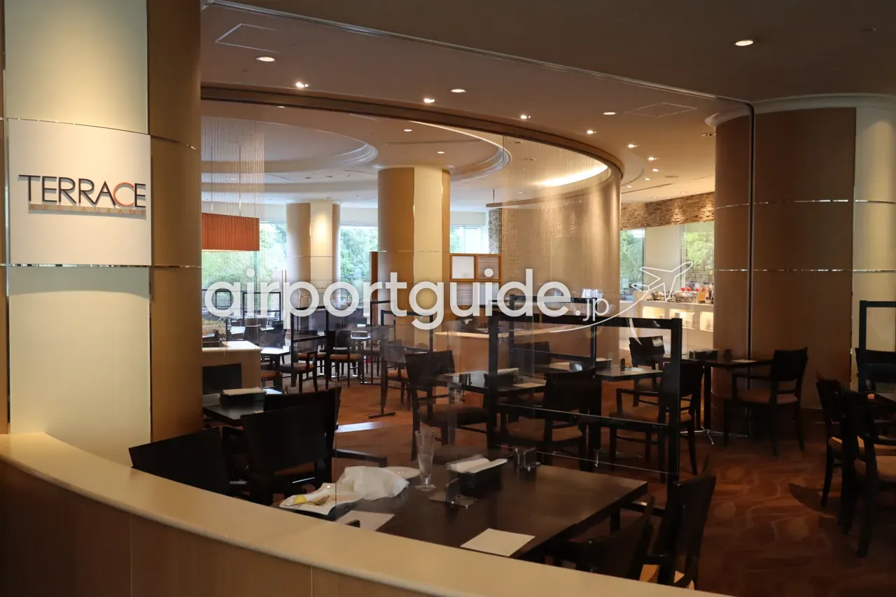 ヒルトン成田のレストラン「TERRACE」の店内。木目の円柱と丸天井、テーブル席が並ぶ。