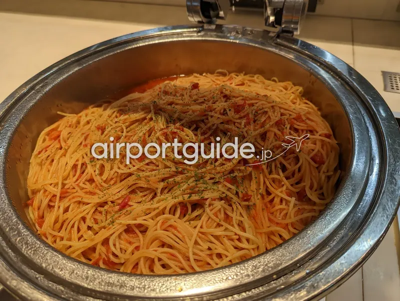 ホテル朝食ブッフェのトマトソースのスパゲッティ。ステンレスの保温容器に盛られる。