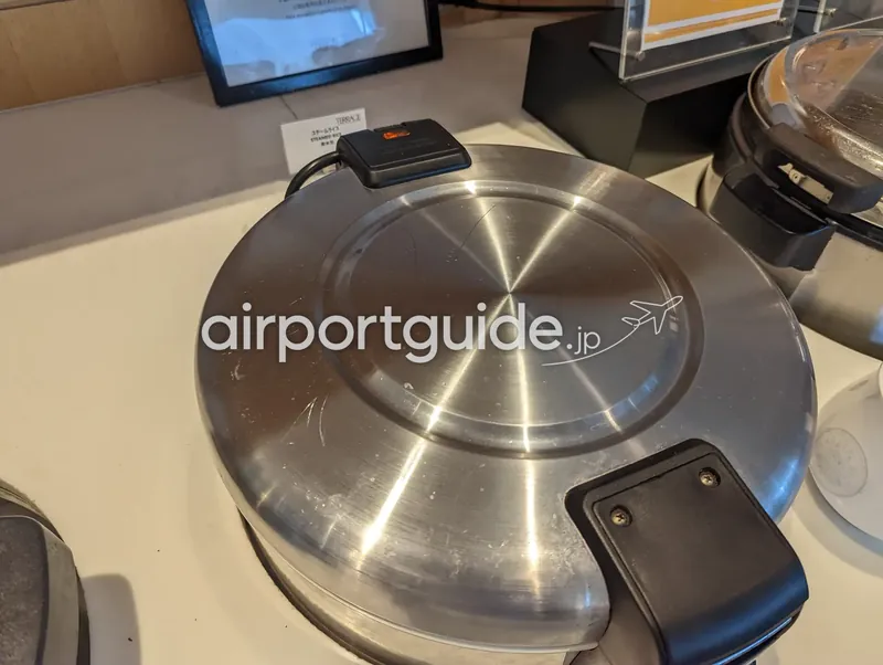 ライス保温器。フタ付きステンレス鍋とSTEAMED RICEの案内カード。