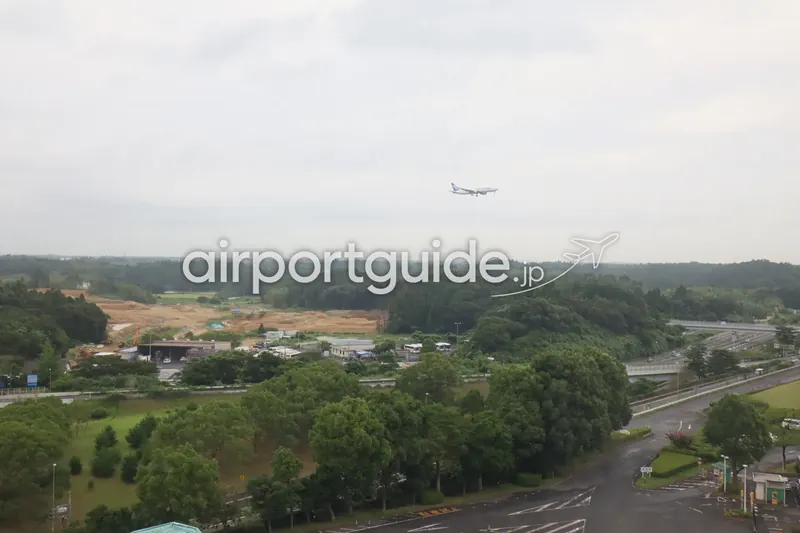 ホテル周辺の上空を飛ぶ旅客機。成田の里山と高速道路の上をANA機が飛行する。