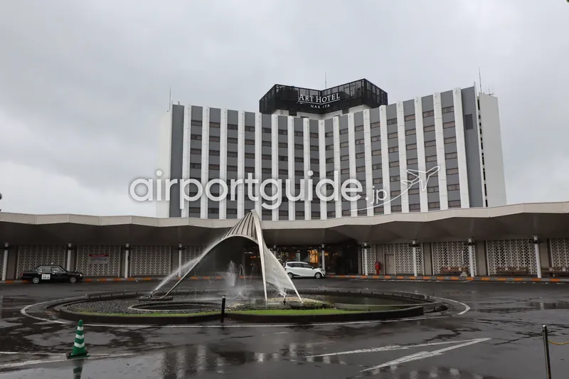 「ART HOTEL NARITA」の外観。曲面を描く高層の客室棟と前庭のアーチ噴水。