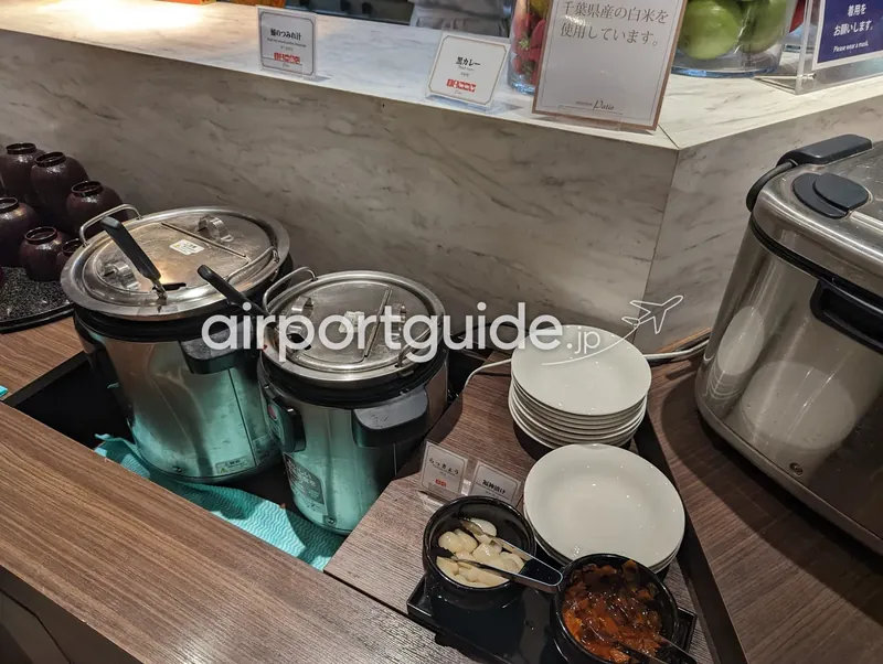 汁物・カレーコーナー。蟹のつみれ汁と黒カレーの保温ジャー、らっきょう・福神漬けの薬味。