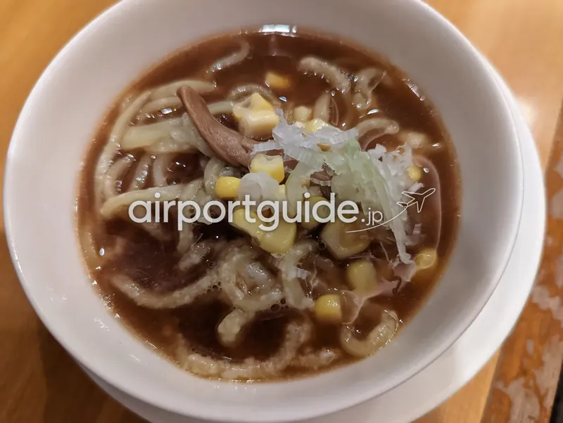白い丼に盛られた醤油ラーメンのアップ。コーン・ねぎ・きのこ入り。