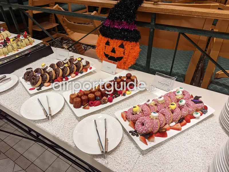 ハロウィン仕様デザートビュッフェ。ドーナツやカヌレが並ぶ。