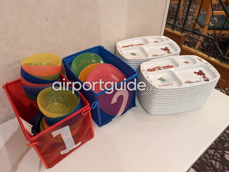 ビュッフェ会場の子供用食器（カラフルなボウルとキャラクター仕切り皿）のストック。