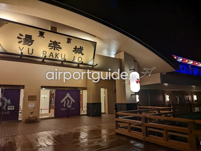 スパ・温浴施設『東京 湯楽城（YU RAKU JO）』の夜の入口。ライトアップされた看板と暖簾。