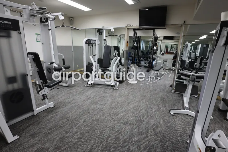 ホテルのフィットネスジム。ウェイトトレーニングマシンが並ぶトレーニングルーム。