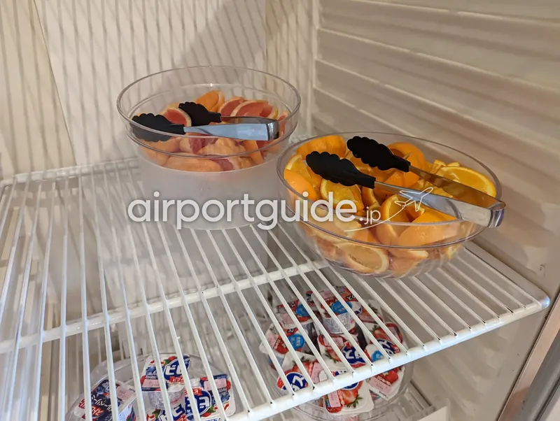 ホテル朝食の冷蔵ケース。カットグレープフルーツとオレンジ、下段に個包装ヨーグルト。