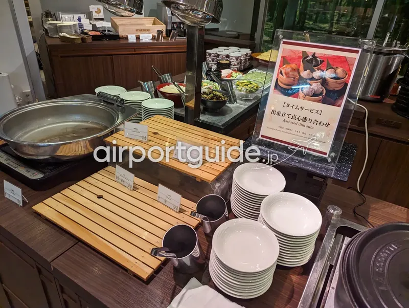 点心コーナー。取り皿や料理カードと並んで点心の案内が立つ。