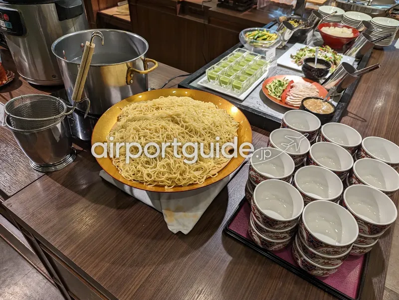 自分でゆでる中華麺コーナー。ゆで麺の大皿、寸胴鍋、絵付けの湯呑み型の器が並ぶ。