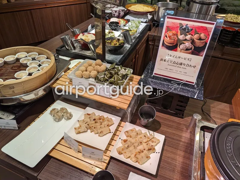 点心コーナーの俯瞰。せいろ・胡麻団子・ちまき・大根餅・焼売と点心の案内パネル。