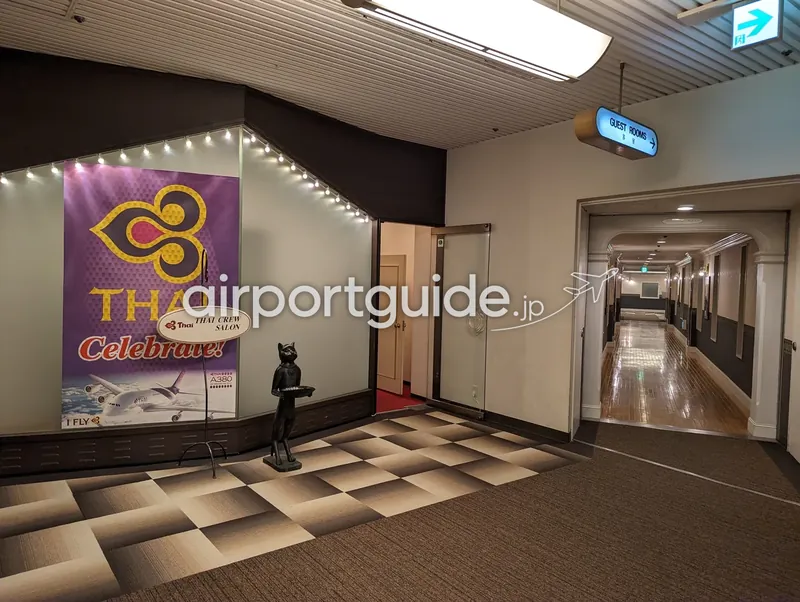 成田近郊ホテルの廊下。客室方向の案内と、タイ航空クルー向けの掲示がある。