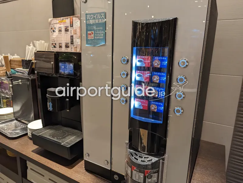 ホテル朝食会場のコーヒーディスペンサーの接写。タッチ式のドリンク選択パネル。