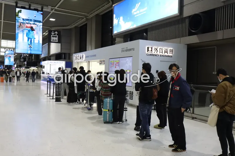 成田空港のGPA外貨両替専門店「外貨両替 CURRENCY EXCHANGE」窓口に多くの利用客が列を作る様子。