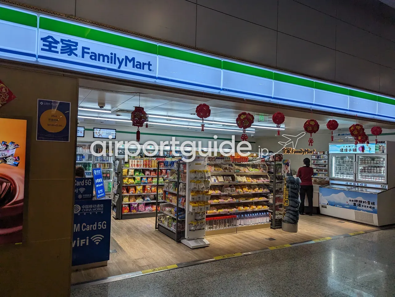 上海浦東空港のコンビニ『全家 FamilyMart』の店頭。赤提灯の装飾と商品棚、『SIM Card 5G／WiFi 中国移动通信 China Mobile』の広告、飲料やスナックの陳列。
