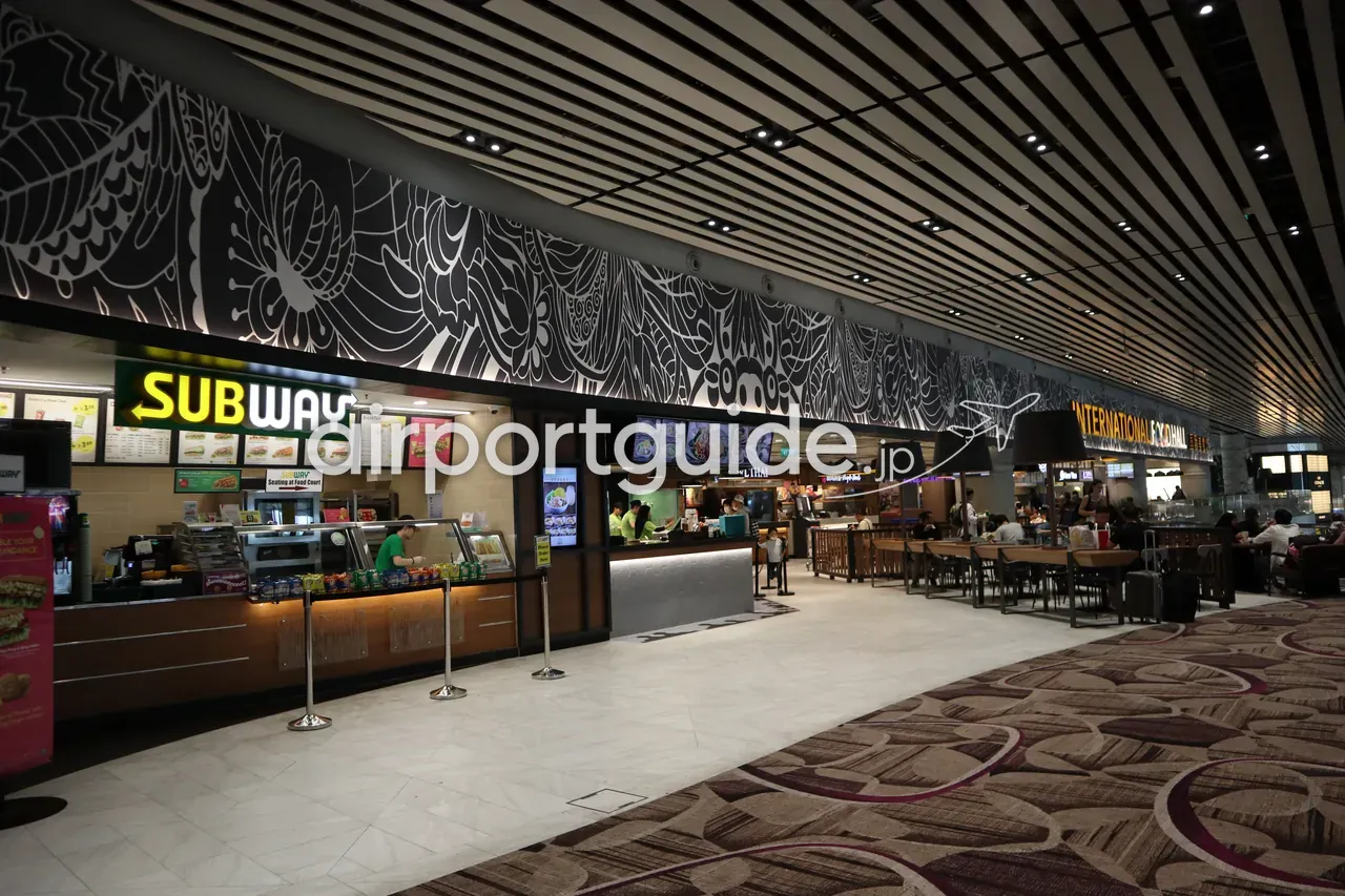 チャンギ空港のフードコート「INTERNATIONAL FOOD HALL 国际美食」。Subway やタイ料理などの店舗と、テーブル席が並ぶ。