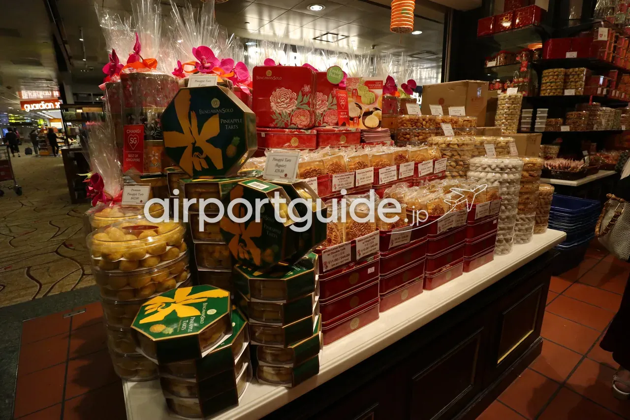 チャンギ空港の土産店の陳列。Bengawan Solo のパイナップルタルトの缶や、「Best of Singapore」表示の菓子が積まれる。